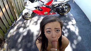 A skinny ebony girl is getting naked outside next to a bike