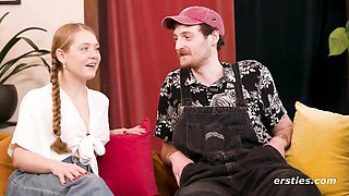 Blonde with braid and brunette talk on blue couch