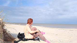 A biker girl strips naked and masturbates on a wild beach.