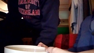 Jen is filming John when he is peeing into a small bowl