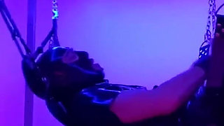 Rubber slave fucked in sling