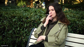 Young Brunette Is Taking an Unhurried Stroll with Allwhite 120mm Cigarette